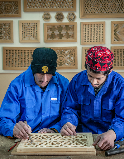 Artisan painting intricate details on wooden panel
